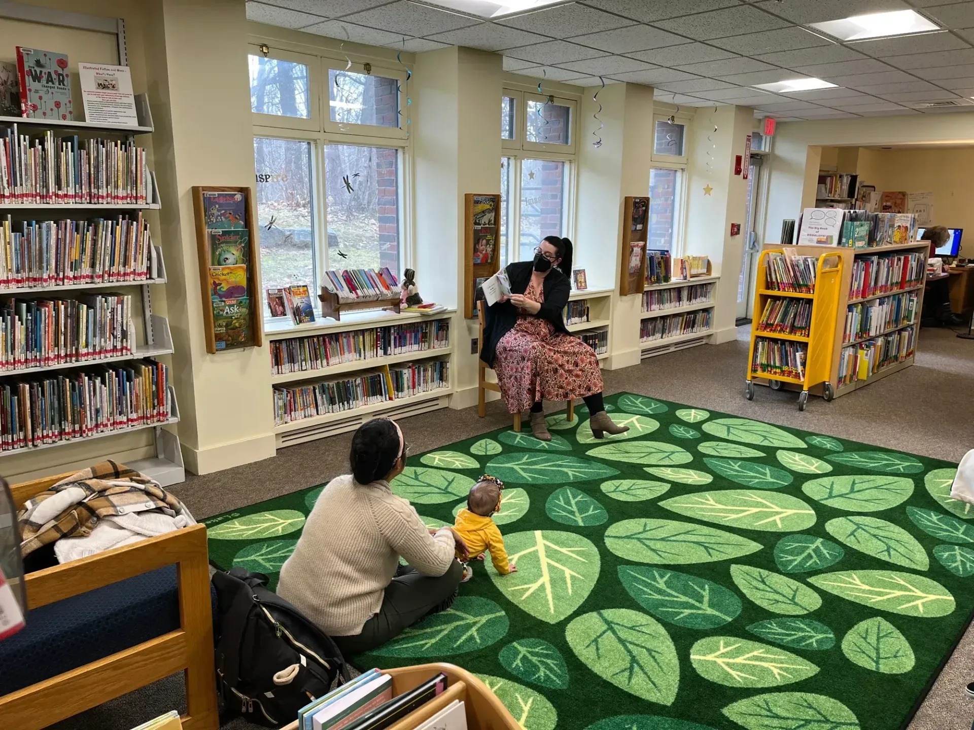 Children's librarian reading a book to a storytime group